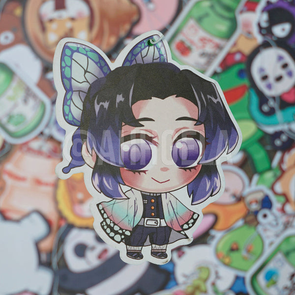 A custom-designed air freshener featuring an anime-style character with purple hair and butterfly wings, from the brand Ahhgela.